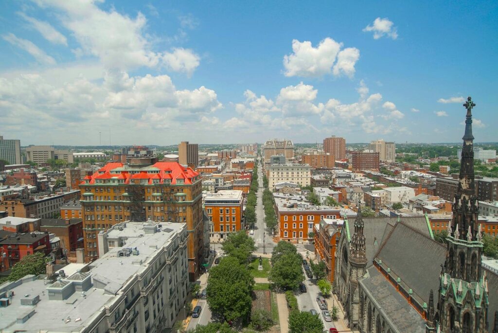 Photo by Germar Derron A vibrant aerial view of Baltimore featuring a historic church spire and urban landscape.